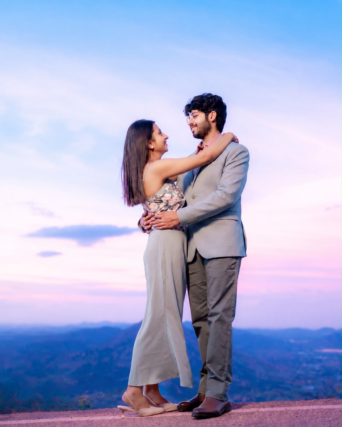 Deblina and Shoureen embracing on a hilltop at dusk